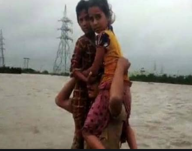 VIDEO: बाढ़ के बीच कंधे पर बैठाकर पुलिस ने बचाई 2 बच्चियों की जान, लोगों ने हनुमान से की तुलना